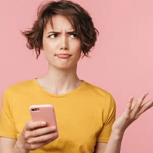 Lady holding a phone with a look of confusion