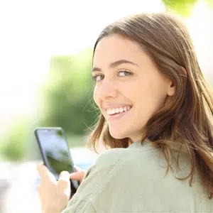 Woman smiling as if texting on her phone