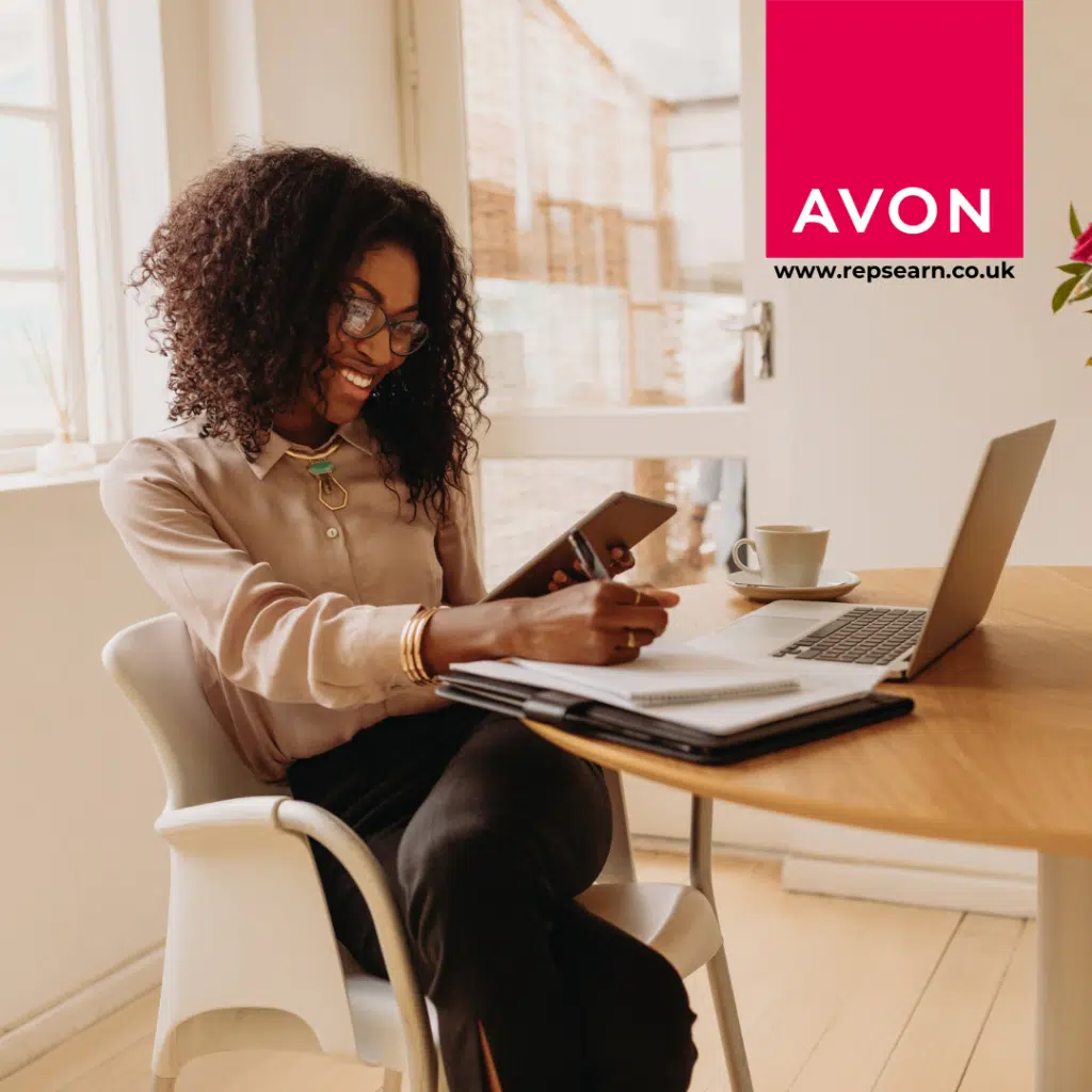 Lady sat smiling at her computer with her phone. Happy that she can work from home with no experience.